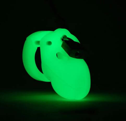 Glow-in-the-dark chastity kit in green light, featuring a compact 1.75-inch cage for discreet wear and nighttime fun.