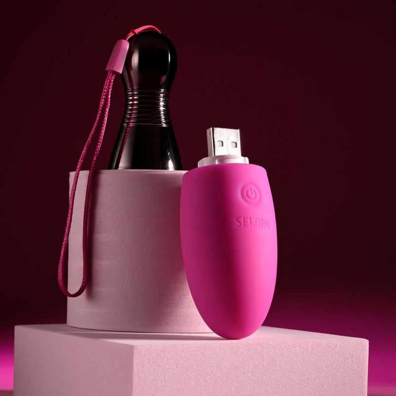 Selopa Companion pink USB rechargeable vibrating egg with chrome handle and 10 speeds & patterns on display on pink podium