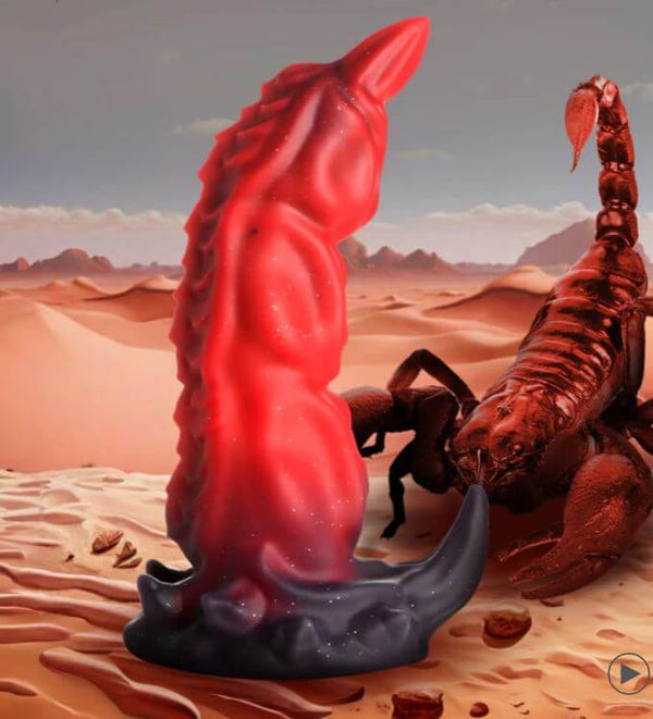 Fantasy-inspired red and black King Scorpion silicone dildo with suction cup base, featuring silver glitter, next to a scorpion in a desert.