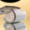Hand holding PLAYBOY Spin Doctor dual entry spinning stroker with sleek black and pearl finish on a reflective surface.