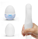Tenga Egg Bouncy Stroker in white design with hand holding the stretchy pleasure device.