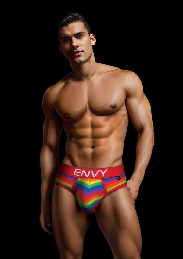 Man wearing Envy Rainbow Pride Briefs in Red S/M, featuring a vibrant rainbow pattern and comfortable fit.