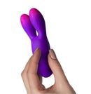 Glo Girl Bunny Vibrator Pink Purple held in hand, showcasing its flexible tips and ergonomic design.