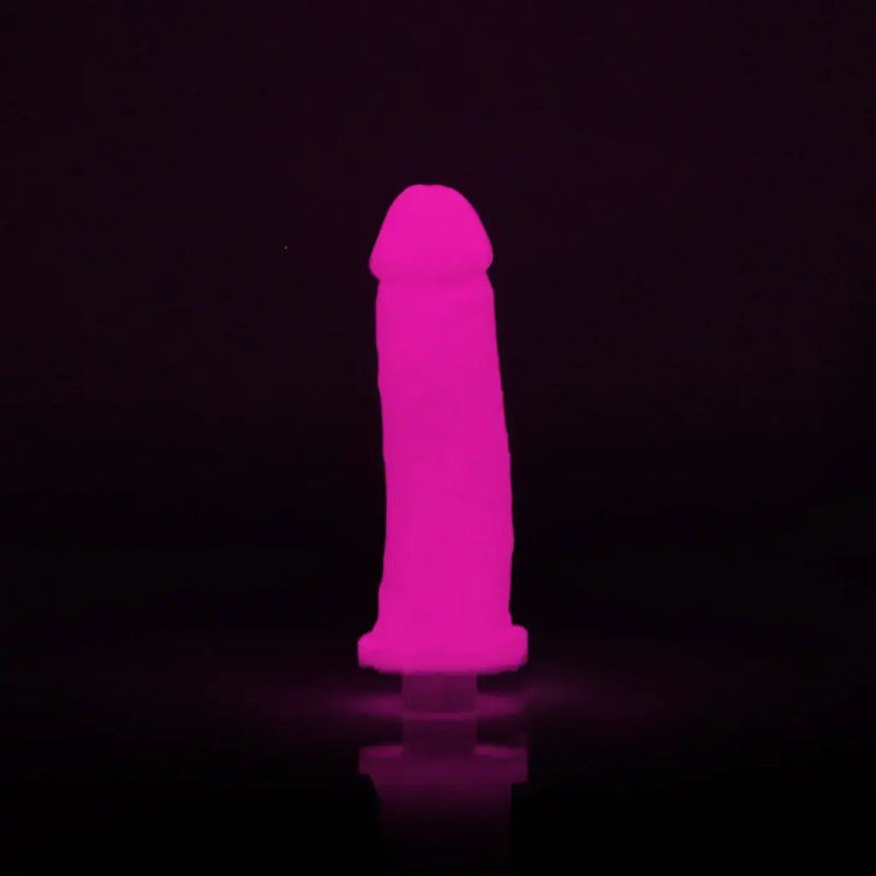 Clone-A-Willy Hot Pink Glow In The Dark Vibrating Silicone Dildo Kit illuminated against a black background.