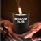 Bedroom Bliss Lover's vanilla scented massage candle held in hands with a lit flame, perfect for wax play and sensual massage