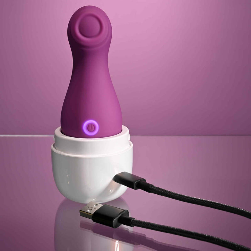 Purple Playboy Jet Set Tapping Toy with Self-Charging Case for clitoral stimulation on a pink background