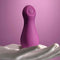 Playboy Jet Set Tapping Toy for Clitoral Stimulation in Purple on Hand Against Pink Background