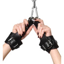 Strict Leather Fleece Lined Suspension Cuffs being held in hands with a black leather design and metal clips.