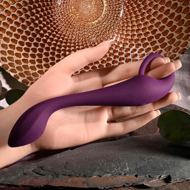 Evolved Lochness G Vibrator with ring handle for G-spot stimulation, displayed against a decorative background.