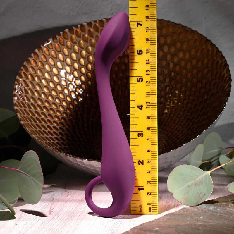 Evolved Lochness G Vibrator measured against a ruler showing off its arched shaft and ring handle for G-spot stimulation.