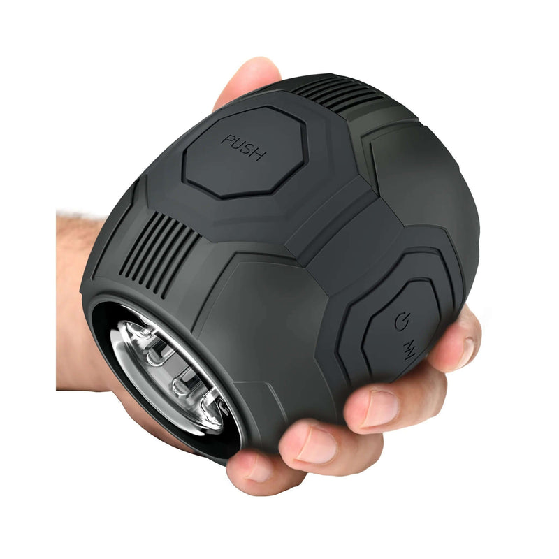 Hand holding The M For Men Dome X automatic male masturbator by Blush with sleek design and easy-squeeze grip for intensified pleasure.