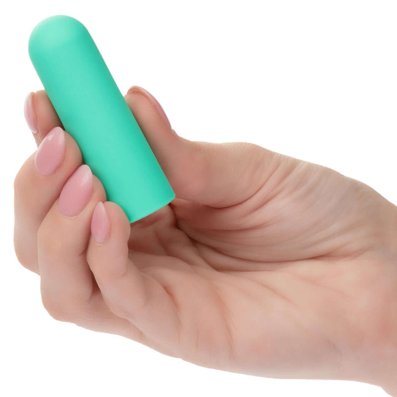 Compact green Turbo Buzz Round Mini Bullet vibrator held in hand for discreet pleasure with 10 functions, made of body-safe materials.