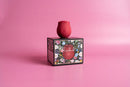 Alchemy Rosebud Luxury Air-Pulse Massager Red displayed on floral box with pink background.