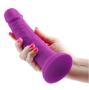 Colours Pleasures Silicone Vibrating Dildo 7 inches Purple held in a hand, showcasing its realistic design.
