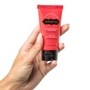 Kama Sutra Pleasure Balm Strawberry Dream Body Gel in a hand, showcasing its playful, kissable formula.