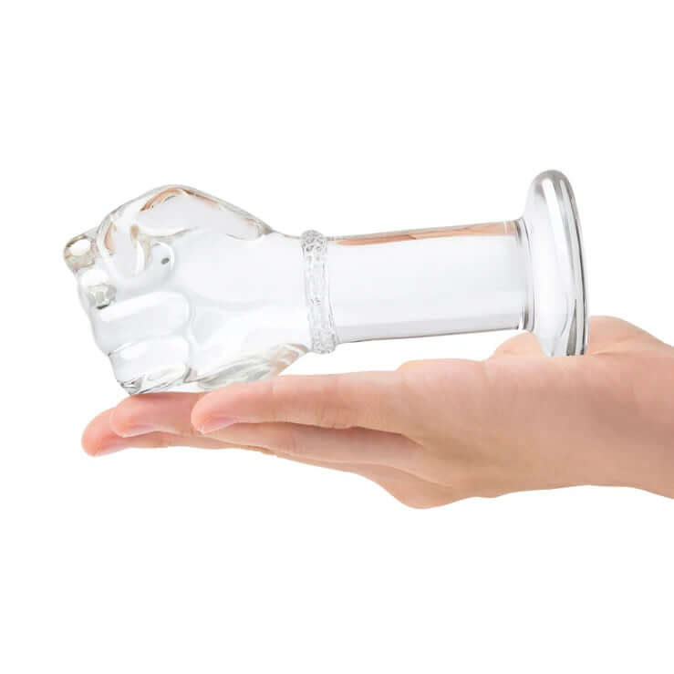 Gläs 5 Inch Glass Fist Butt Plug with Realistic Hand Texture and Tapered Base held in a hand.