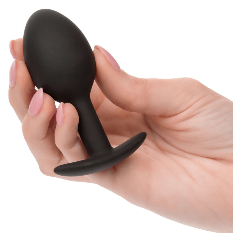 Hand holding a black Weighted Silicone Plug with ergonomic design for enhanced sensory pleasure