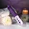 EVOLVED Plum Thrust Vibrator with towels, flowers, and a candle in the background