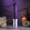 The EVOLVED Plum Thrust powerful thrusting vibrator with realistic design and USB rechargeable feature displayed with candles and flowers.