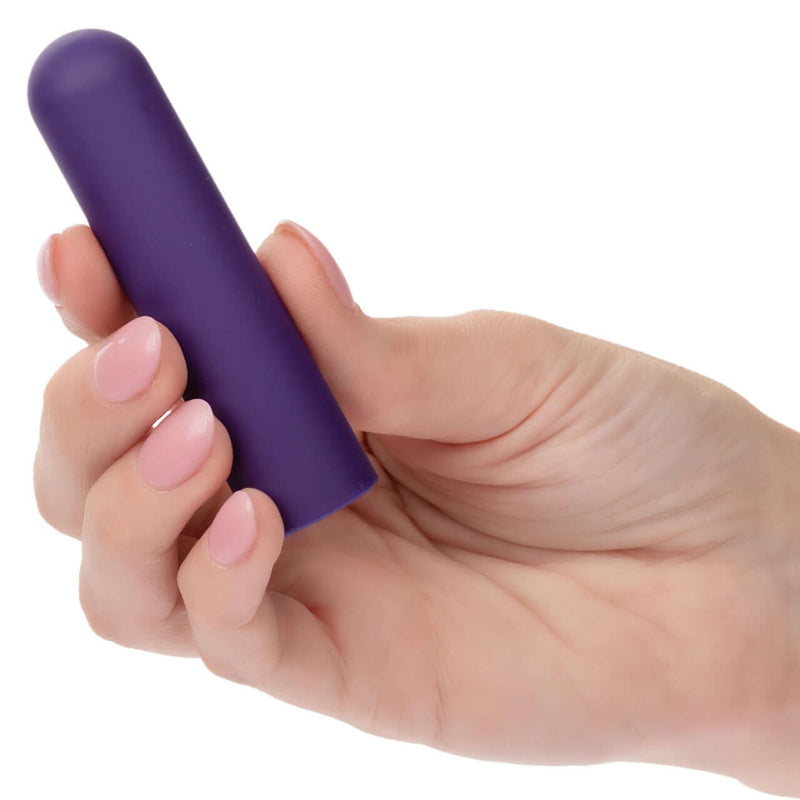 Hand holding Turbo Buzz™ Rounded Bullet purple compact 10-function vibrator for discreet and powerful on-the-go pleasure