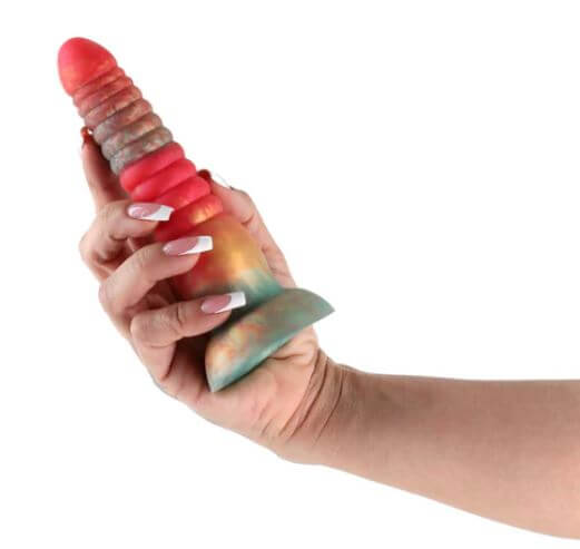 Person holding a 6-inch stacked silicone dildo in red and gold colors, showcasing its design and texture.