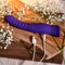 Selopa Trixxxie Vibrator USB charging on wooden surface, surrounded by flowers