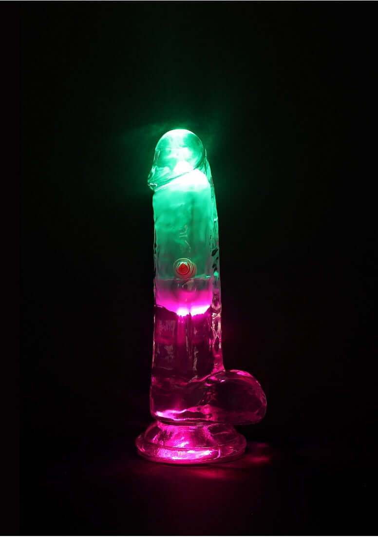 RealRock Vibrating Dildo 6 inch with Balls and Remote Control in vibrant colors against a dark background.