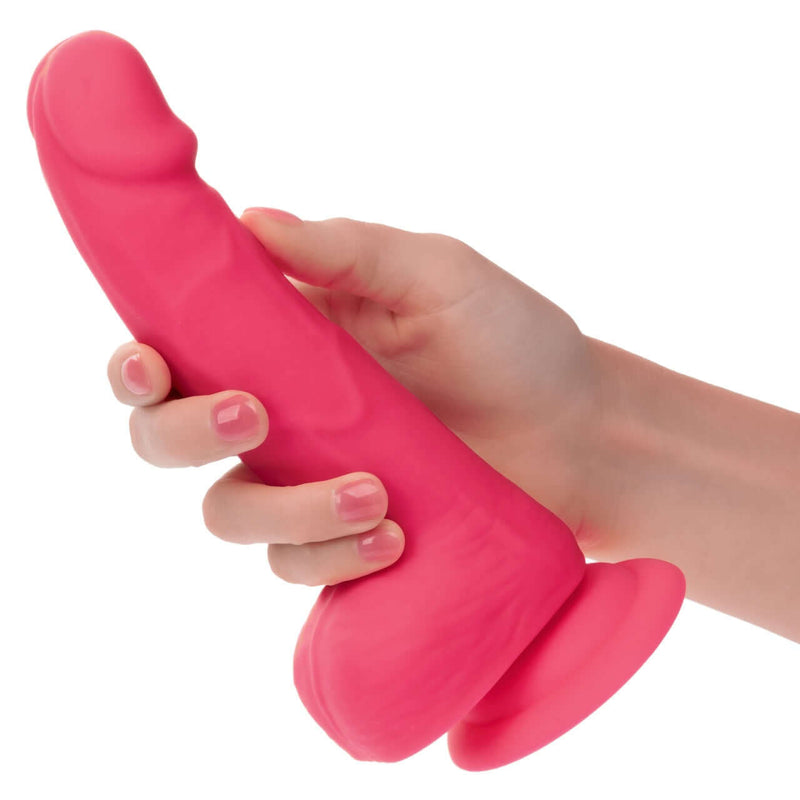 Hand holding vibrant pink Neon Silicone Studs 6 Inch, lifelike and realistic silicone pleasure product.