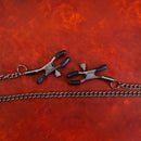 Sei Mio Nip And Tug Adjustable Nipple Clamp Chain showcasing durable clamps and chain links on a textured surface.