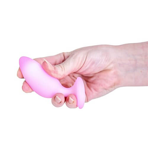 Softies Dual Layer Butt Plug 4 inches Pink held in hand, showcasing its smooth silicone design and tapered tip.
