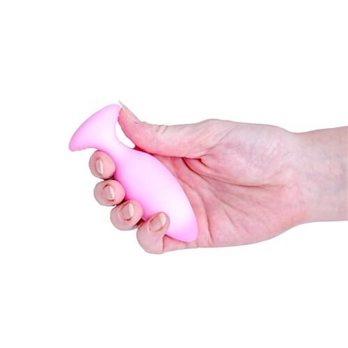 Softies Dual Layer Butt Plug 4 inches Pink being held in a hand, showcasing its ergonomic design.