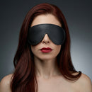 Strict Leather Padded Blindfold worn by a model, enhancing sensory deprivation and anticipation in bondage play.
