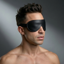 Strict Leather Padded Blindfold worn by a man, enhancing sensory deprivation during bondage play.