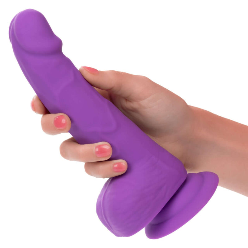 Hand holding CalExotics Neon Silicone Studs 6 Inch Purple realistic dildo