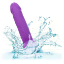 Purple Neon Silicone Studs 6 inch vibrator splashing in water, showcasing waterproof feature of CalExotics silicone pleasure product.