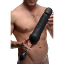 Tom of Finland Toms Inflatable Silicone Dildo held by a model, showcasing its textured design and squeeze bulb.