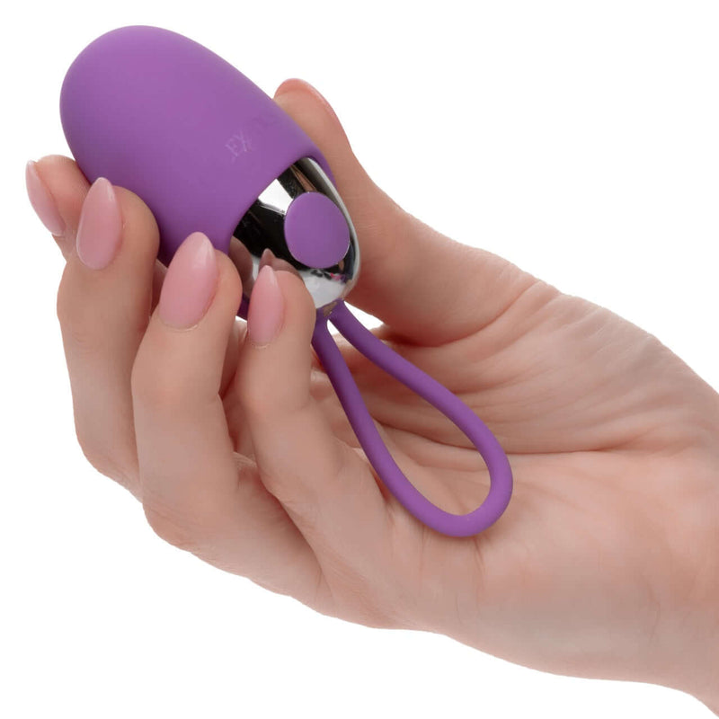 Hand holding the Turbo Buzz™ Bullet with Removable Silicone Sleeve in purple, showcasing its compact design and loop.