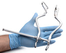 Kink Industries Stainless Steel Anal Hole Spreader Grey held in a gloved hand for anal exploration and stretching.
