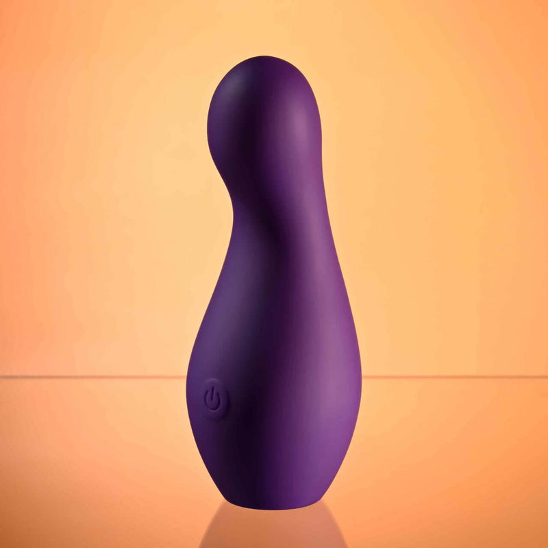 Purple Playboy Jet Set Vibrator with ergonomic design on orange background. Discreet, 10 speeds, self-charging case, waterproof.