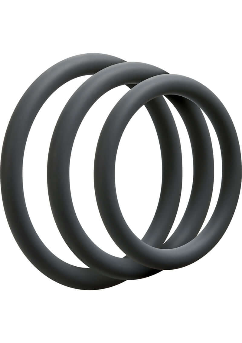 Three slate-colored silicone cock rings from the Optimale Thin Silicone C-Ring Set, designed for enhancing size, girth, and performance.