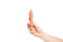 Hand holding Sensuelle 60SX Amp Silicone Bullet Vibrator in Coral, showcasing its compact and powerful design