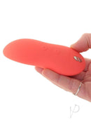 Hand holding We Vibe Touch X Crave Coral multi-purpose vibrator for clitoral stimulation and body massages
