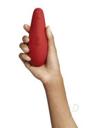 Woman holding the Womanizer Marilyn Monroe Special Edition red clitoral stimulator featuring Pleasure Air Technology.
