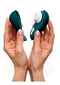 Hands holding Womanizer LIBERTY 2 in Dark Petrol with hygienic magnetic cover. Portable pleasure companion for travel.