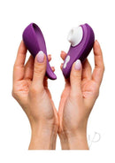 Woman holding the compact and travel-friendly Womanizer LIBERTY 2 in purple with hygienic magnetic cover.