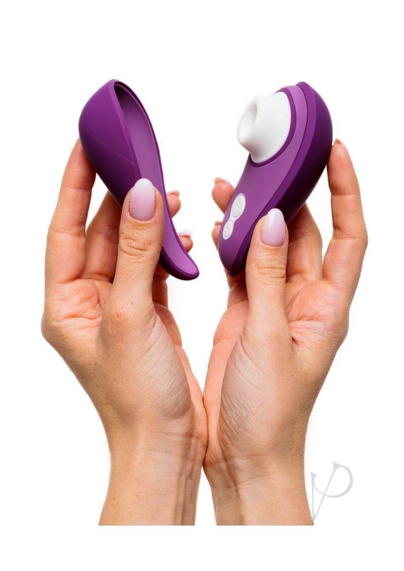 Woman holding the compact and travel-friendly Womanizer LIBERTY 2 in purple with hygienic magnetic cover.