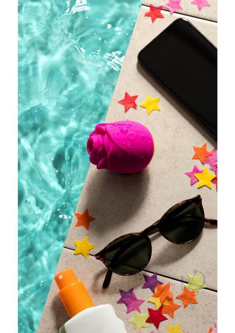 We-Vibe ROMP Rose Pink clitoral stimulator by the pool with sunglasses and scattered stars.