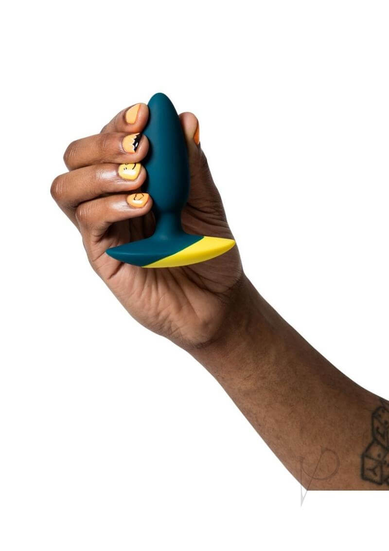 Hand holding ROMP Bass Green vibrating anal plug designed for ultimate anal pleasure and comfort.