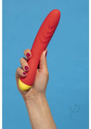 Hand holding ROMP Hype orange G-spot vibrator with curved tip for targeted stimulation.