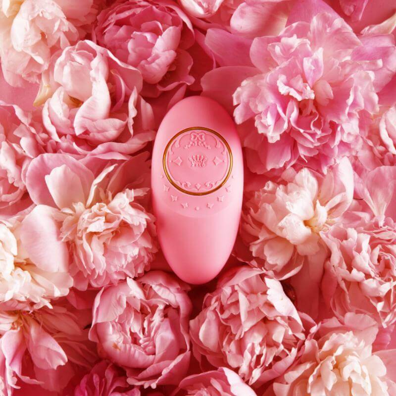 ZALO Jeanne Rouge Pink app-controlled rechargeable massager on a bed of pink flowers, inspired by Versailles luxury and elegance.